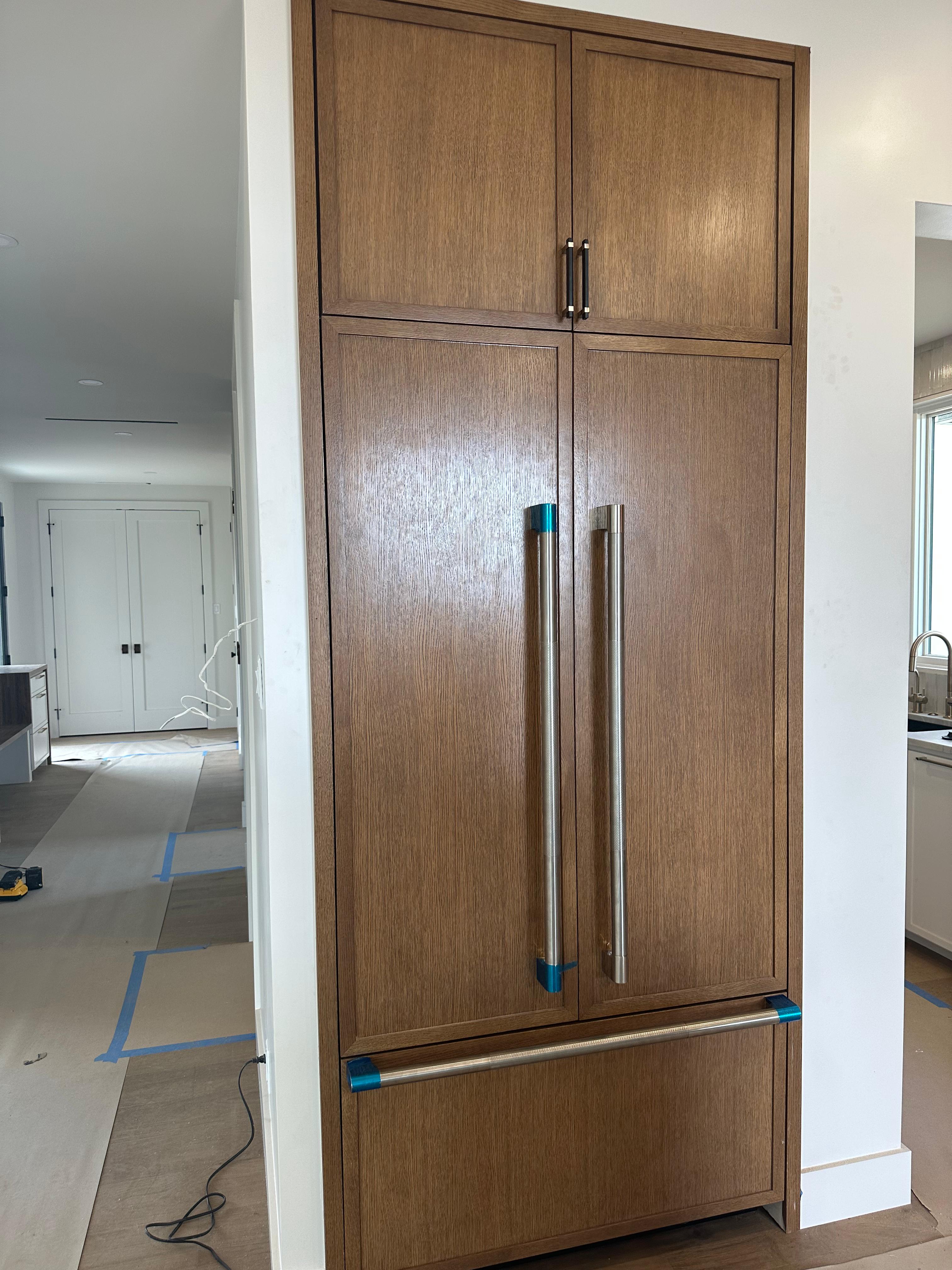 White kitchen cabinets with glass doors and built-in appliances